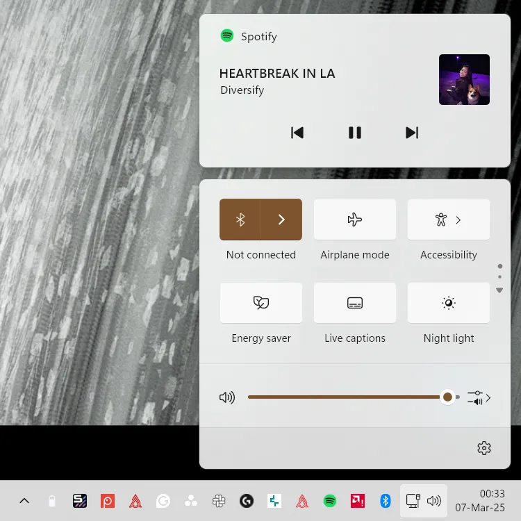 Ảnh chụp màn hình Trung tâm Hành động (Action Center) của Windows 11 hiển thị thông tin điều khiển nhạc Spotify đang phát.