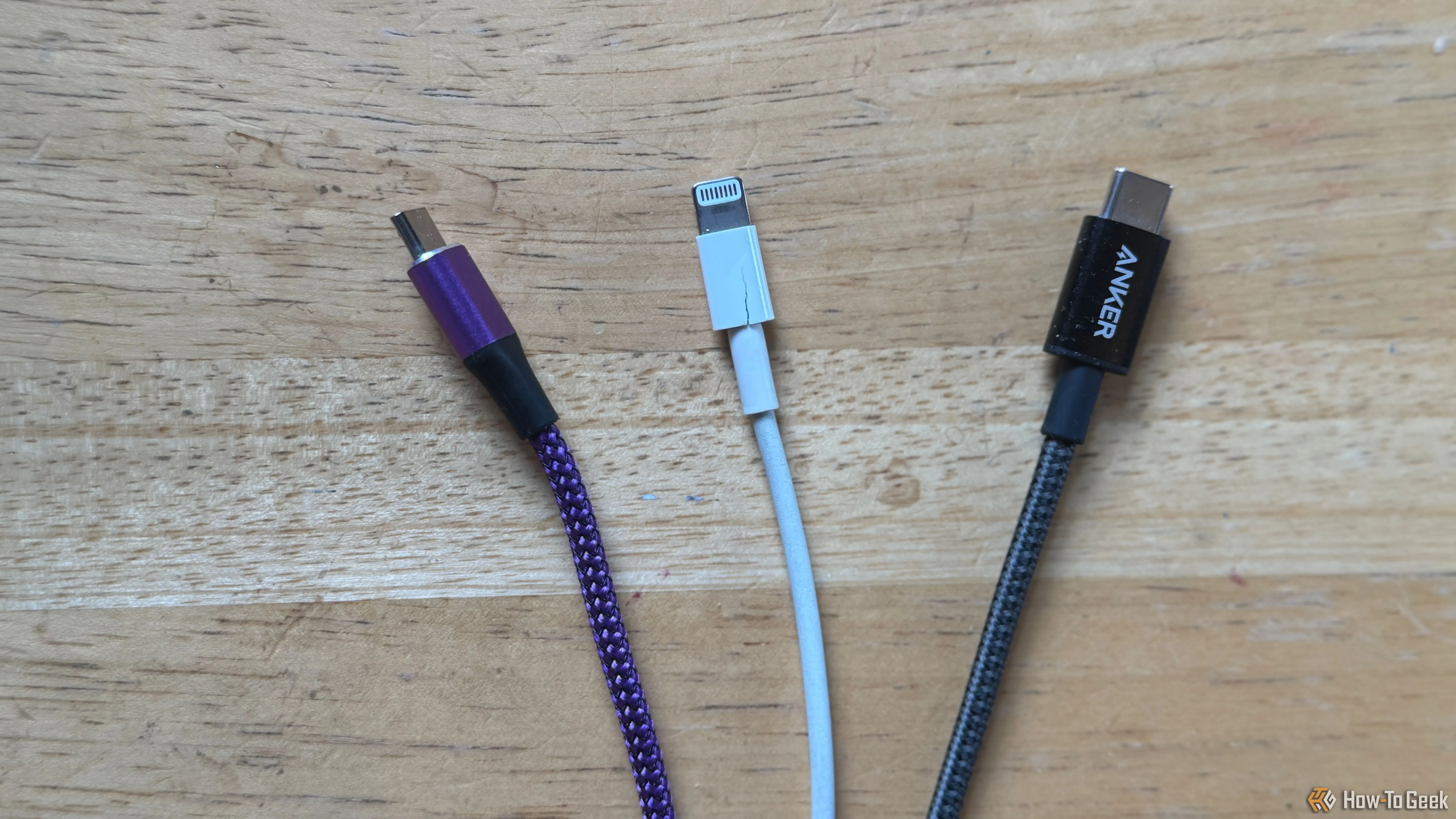 Ba loại cáp sạc Micro-USB màu tím, Lightning màu trắng và USB-C màu xám minh họa cách phân biệt cáp qua màu sắc.