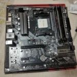 Bo mạch chủ đặt trên vỏ hộp cùng CPU và RAM đã được lắp đặt, sẵn sàng cho bước kiểm tra ban đầu.