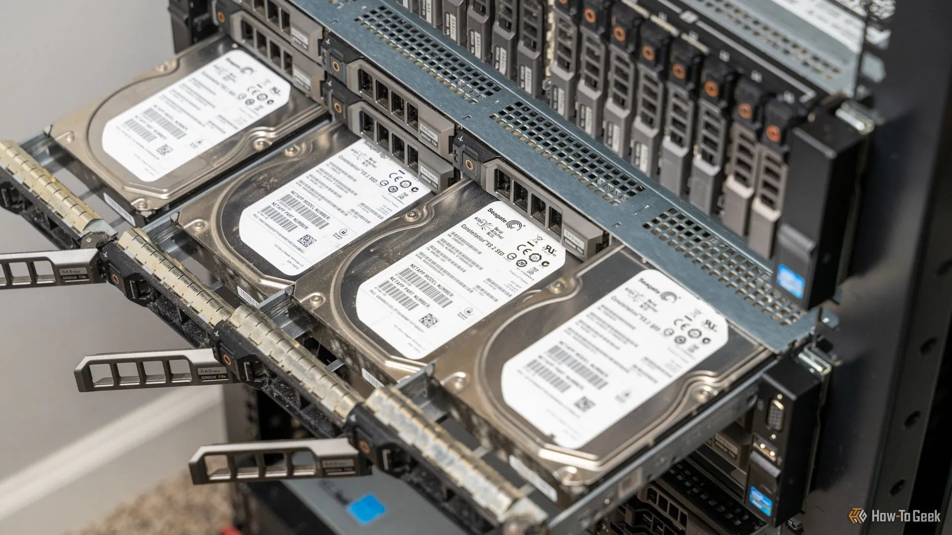 Bốn ổ cứng nhô ra từ máy chủ rack-mount, biểu tượng cho việc lưu trữ và sao lưu dữ liệu