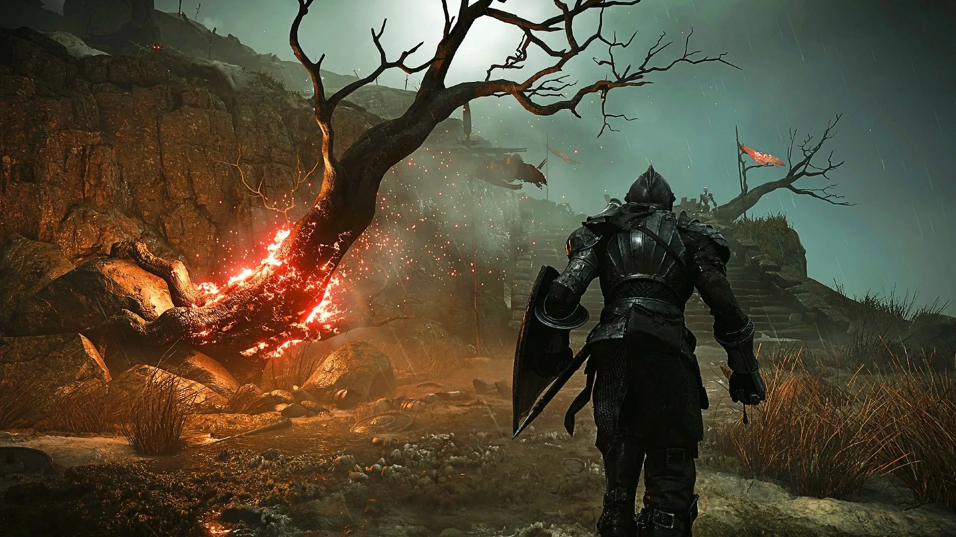 Cảnh người chơi đi bộ cạnh cái cây đang cháy tại Shrine of Storms trong bản remake Demon's Souls, minh họa đồ họa hiện đại của các tựa game được tái tạo hoàn toàn.