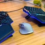 Chuột gaming đặt giữa bàn phím cơ tách rời, minh họa cho tầm quan trọng của việc kiểm soát chuột trong game bắn súng.