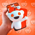 Điện thoại hiển thị linh vật Reddit nổi lên từ màn hình