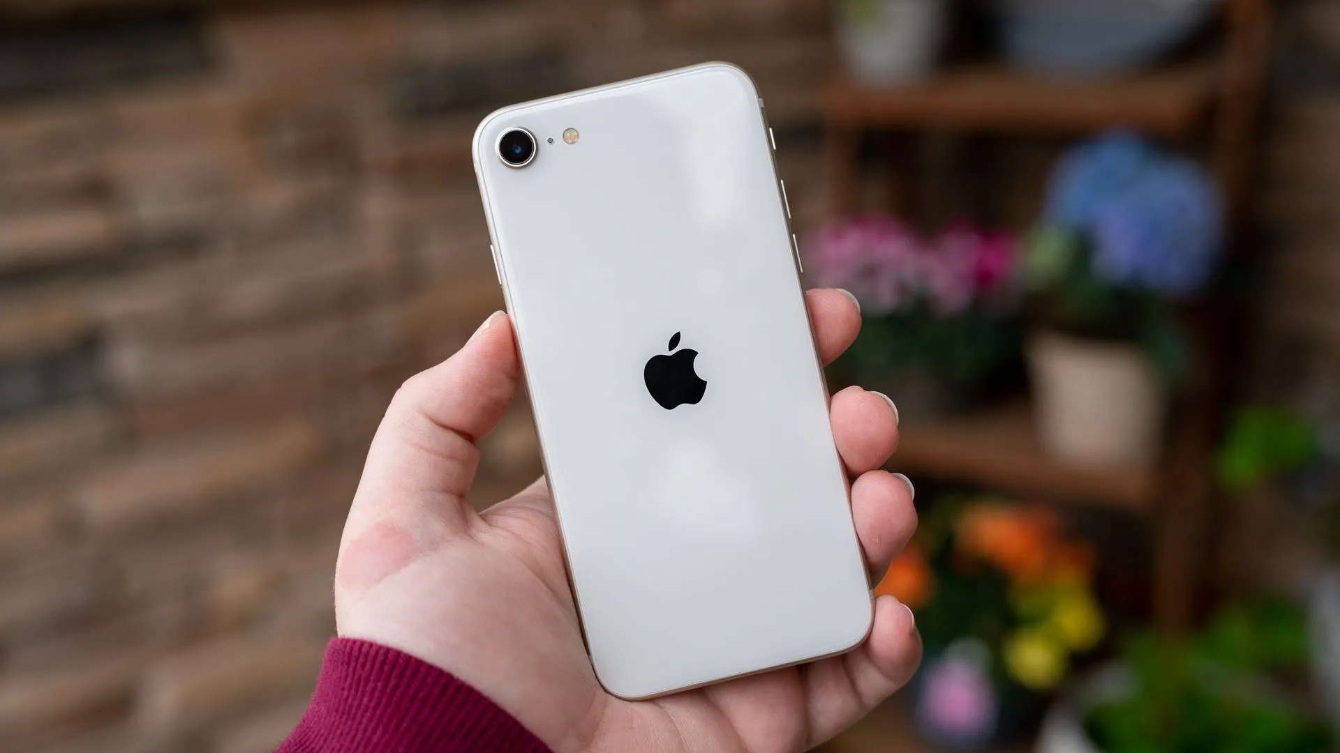 Điện thoại iPhone SE 2022 màu trắng với nút Home và viền màn hình dày