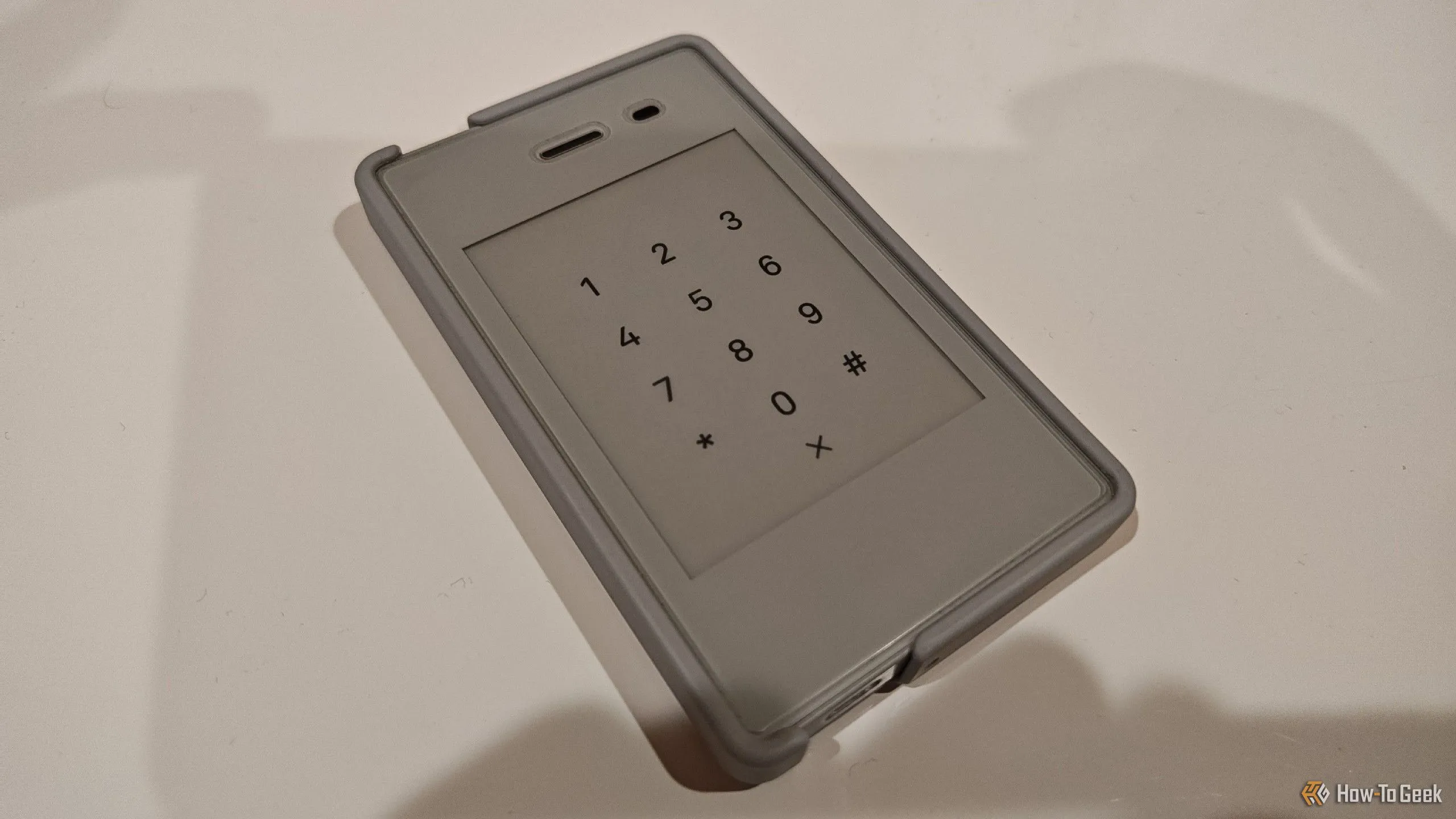 Điện thoại Light Phone 2 với màn hình E Ink đen trắng đặt trên bề mặt màu trắng, minh họa thiết kế tối giản.