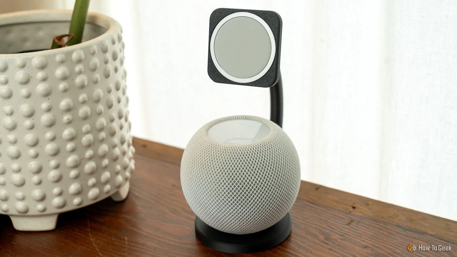 Dock sạc MagSafe in 3D tích hợp loa HomePod mini đặt trên bàn gỗ