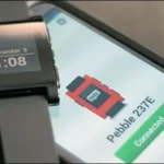 Đồng hồ Pebble cổ điển với màn hình ePaper đen trắng đặt cạnh một chiếc điện thoại thông minh