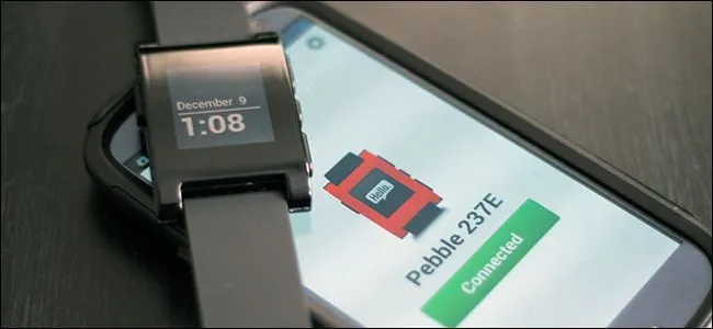 Đồng hồ Pebble cổ điển với màn hình ePaper đen trắng đặt cạnh một chiếc điện thoại thông minh