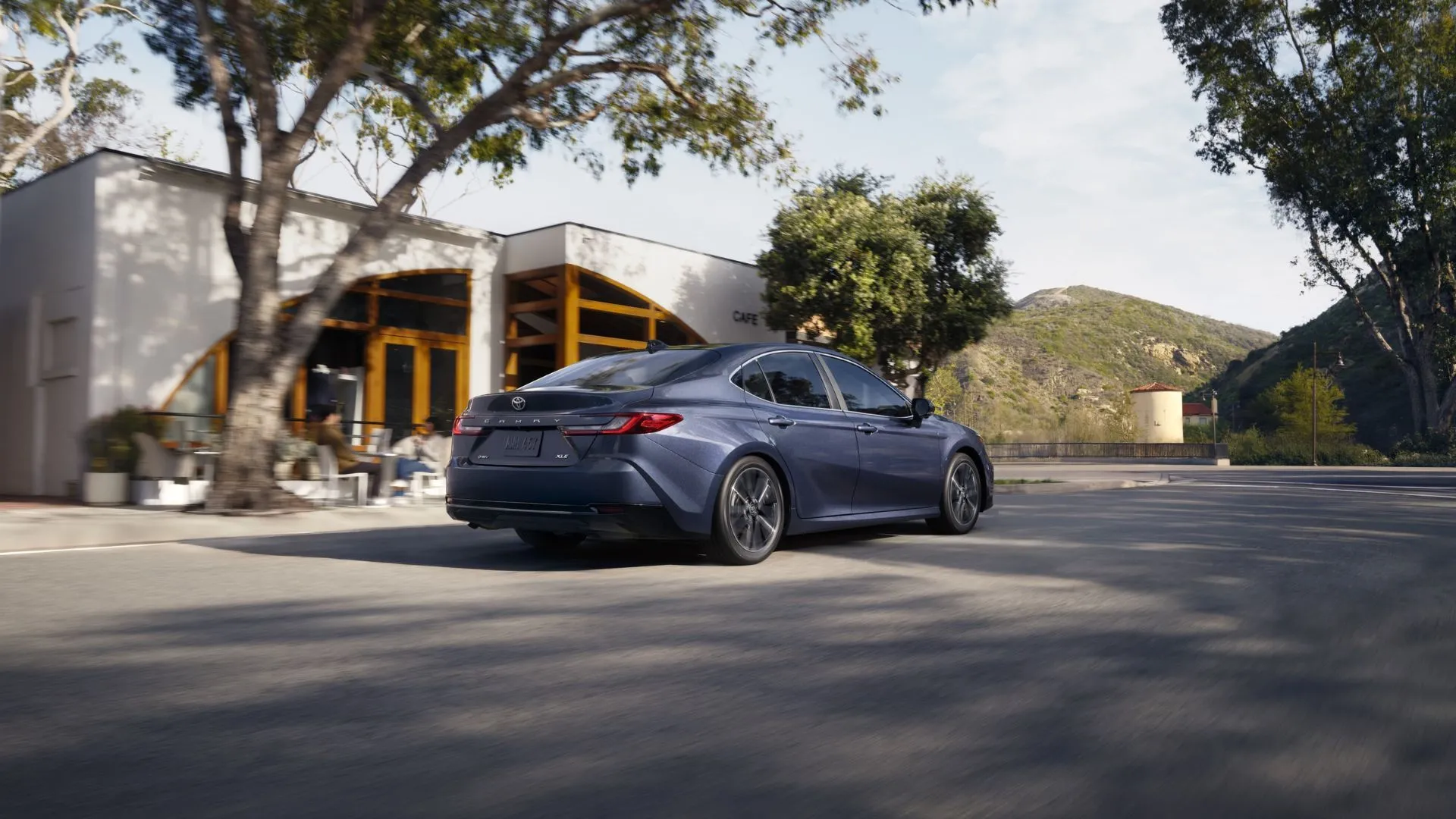 Hình ảnh góc 3/4 phía sau của Toyota Camry 2026 màu xám bạc, làm nổi bật kiểu dáng thể thao và đèn hậu LED.