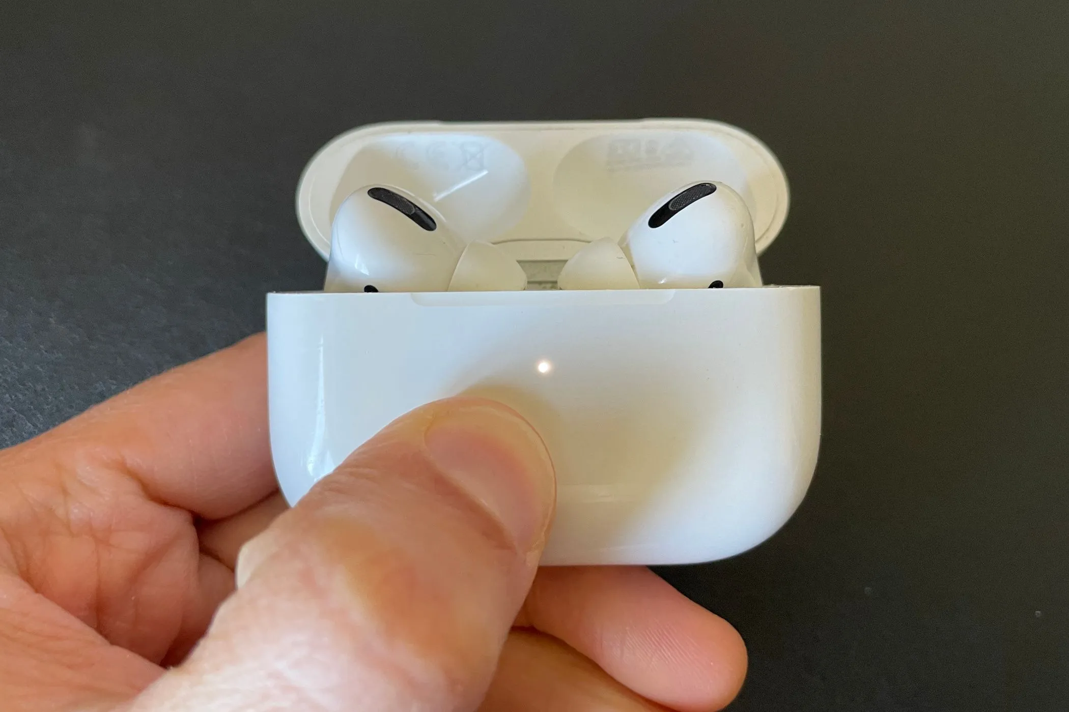 Hộp sạc AirPods Pro mở ra với đèn trạng thái màu trắng, minh họa cho vấn đề pin không thể thay thế và tính &quot;dùng một lần&quot; của tai nghe Apple.