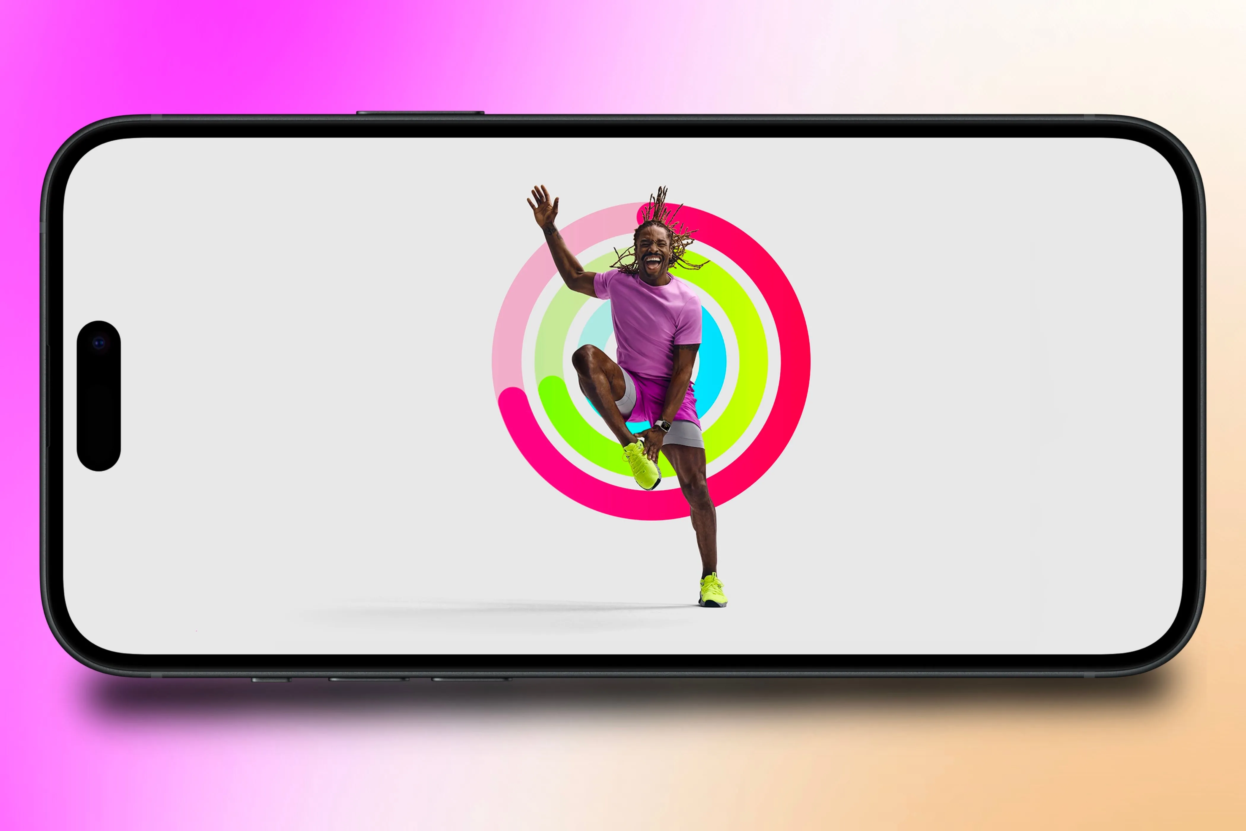 Huấn luyện viên Apple Fitness+ đang tập luyện, phía sau là các vòng Hoạt động trên iPhone.