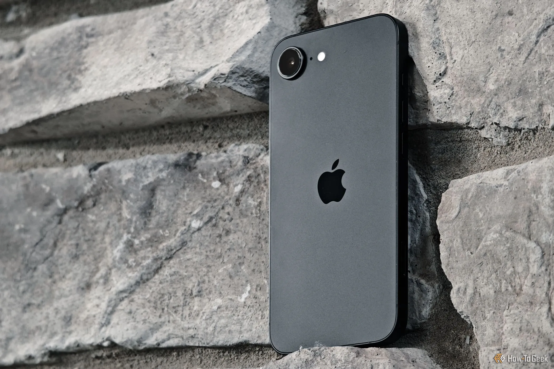 iPhone 16e dựa vào tường gạch, nhấn mạnh vai trò thử nghiệm modem C1 tự sản xuất của Apple