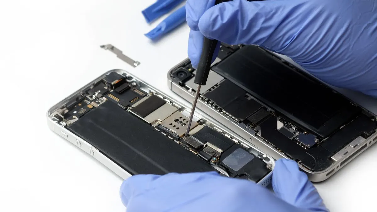 Kỹ thuật viên đang kiểm tra bo mạch điện thoại Samsung tại trung tâm bảo hành