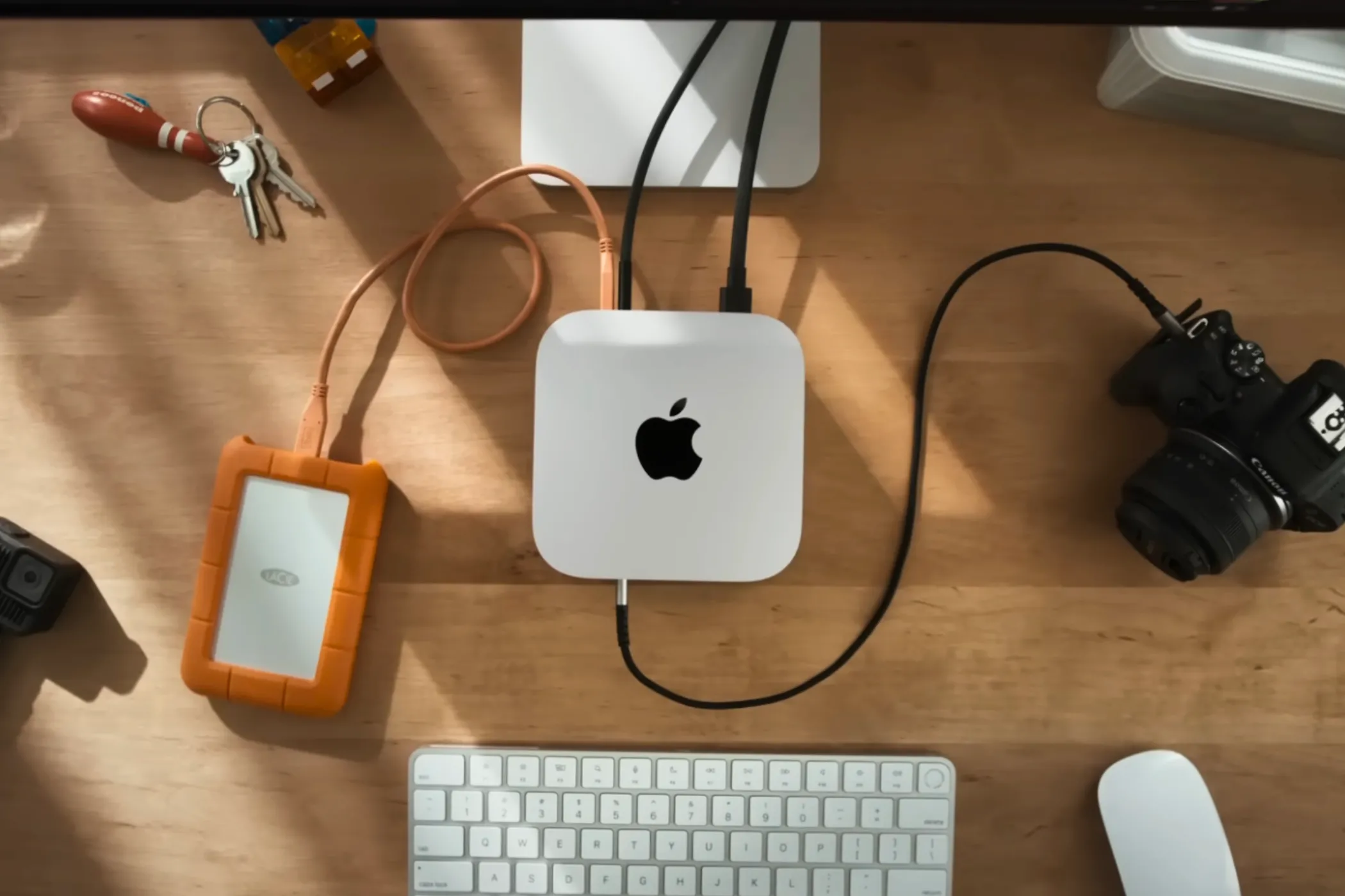 Mac Mini M4 đặt trên bàn làm việc cùng các phụ kiện công nghệ khác.