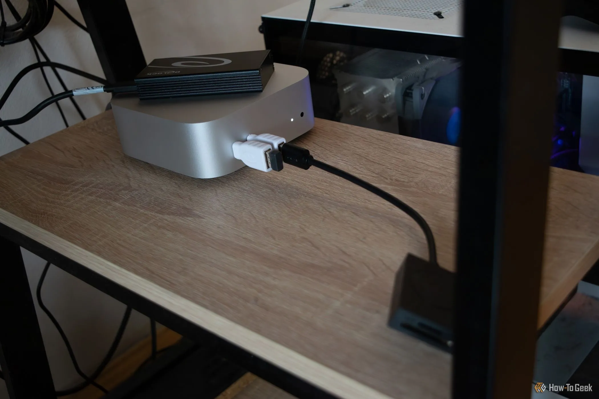 Mac Mini M4 được đặt dưới bàn làm việc, kết nối với ổ SSD gắn ngoài.