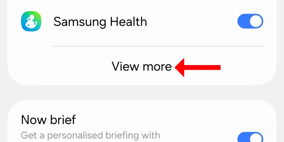Màn hình cài đặt Now Bar trên Galaxy S25, với mũi tên chỉ vào tùy chọn &quot;Xem thêm&quot; trong phần thông báo trực tiếp.