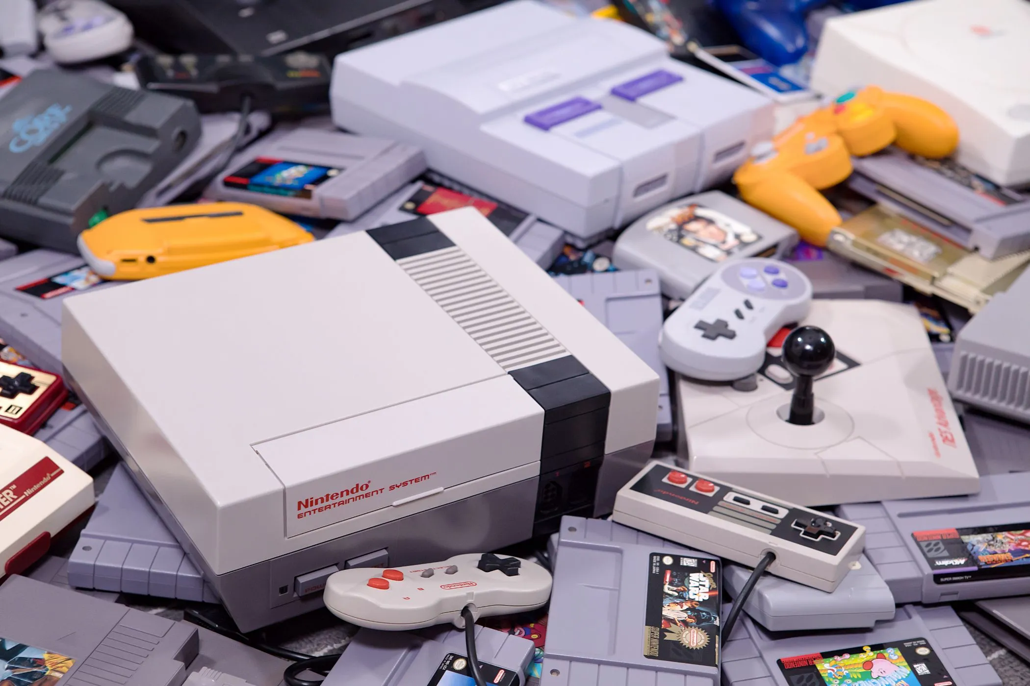 Máy chơi game Nintendo Entertainment System (NES) và Super Nintendo Entertainment System (SNES) với các băng game và tay cầm cổ điển.