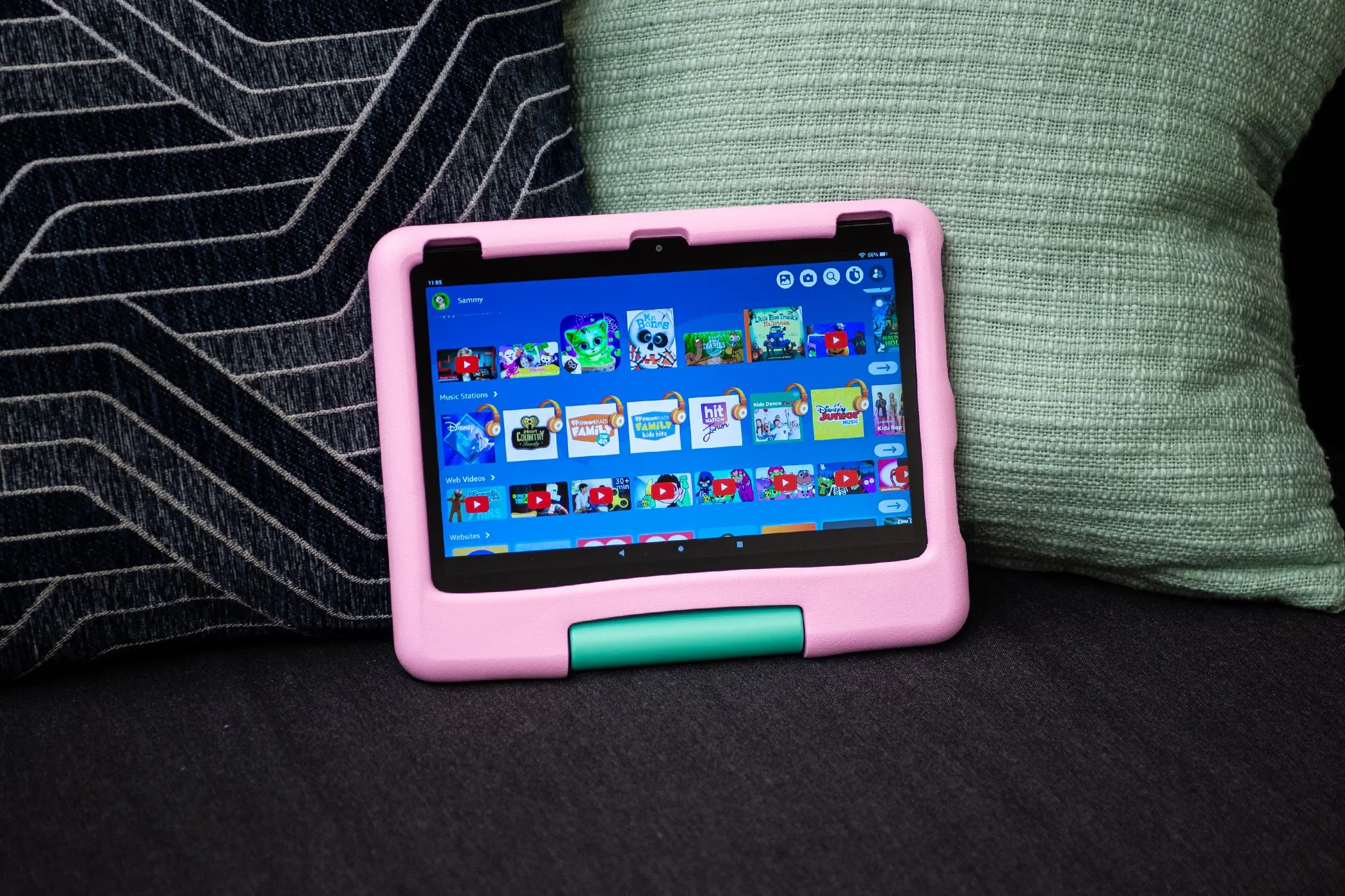 Máy tính bảng Amazon Fire HD 10 Kids màu xanh nằm trên ghế sofa, minh họa thiết bị có giới hạn thời gian sử dụng cho trẻ em.
