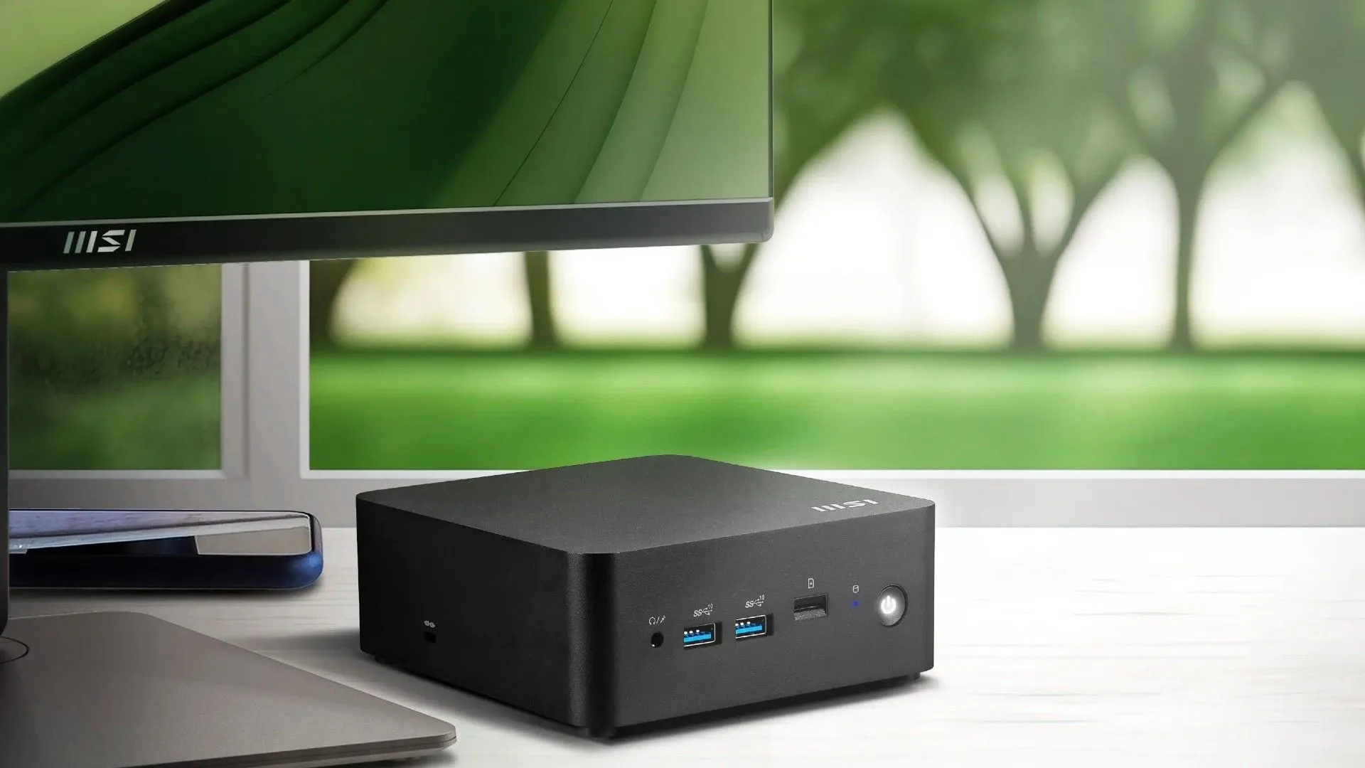Máy tính mini MSI Cubi NUC AI Series đặt cạnh màn hình, nhỏ gọn