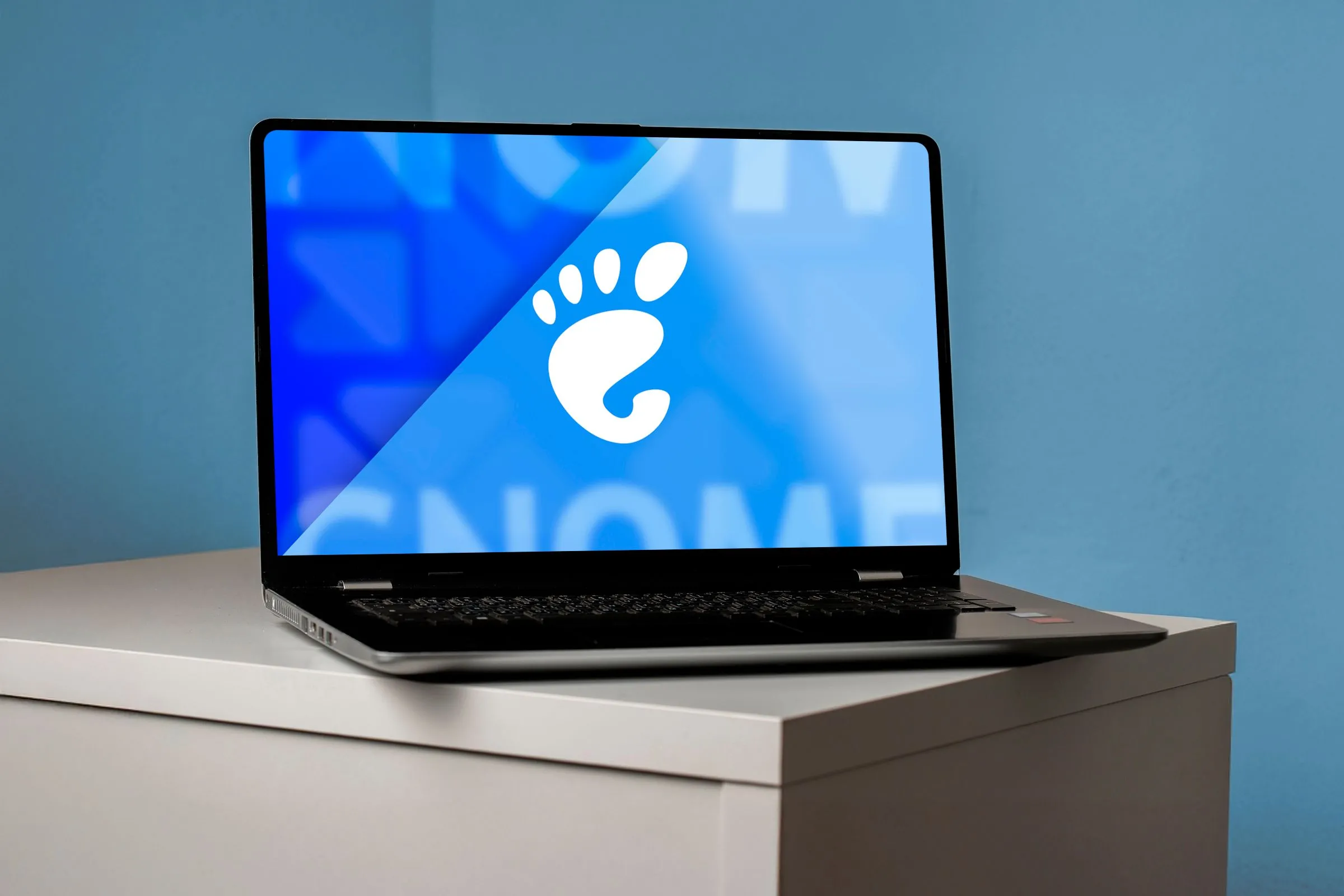 Máy tính xách tay hiển thị logo GNOME trên màn hình, tượng trưng cho môi trường desktop