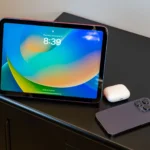 Một chiếc iPad cạnh Airpods và iPhone 14, minh họa cho khả năng kết nối di động của iPad