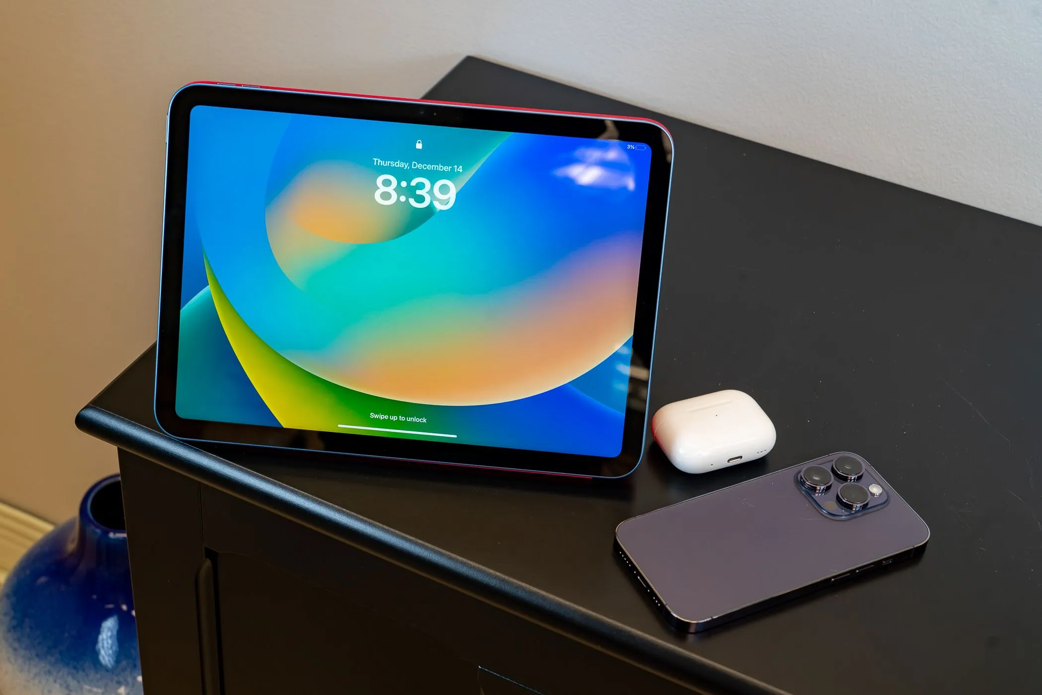 Một chiếc iPad cạnh Airpods và iPhone 14, minh họa cho khả năng kết nối di động của iPad