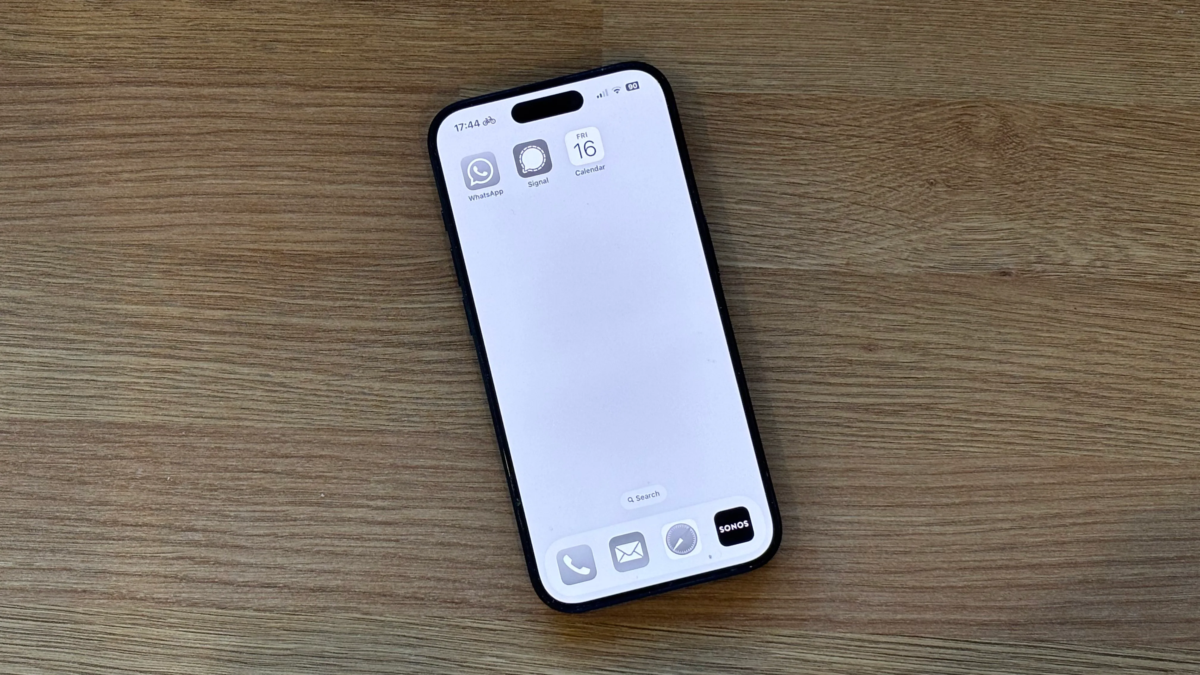 Một chiếc iPhone với màn hình chính màu xám chỉ chứa ba ứng dụng.