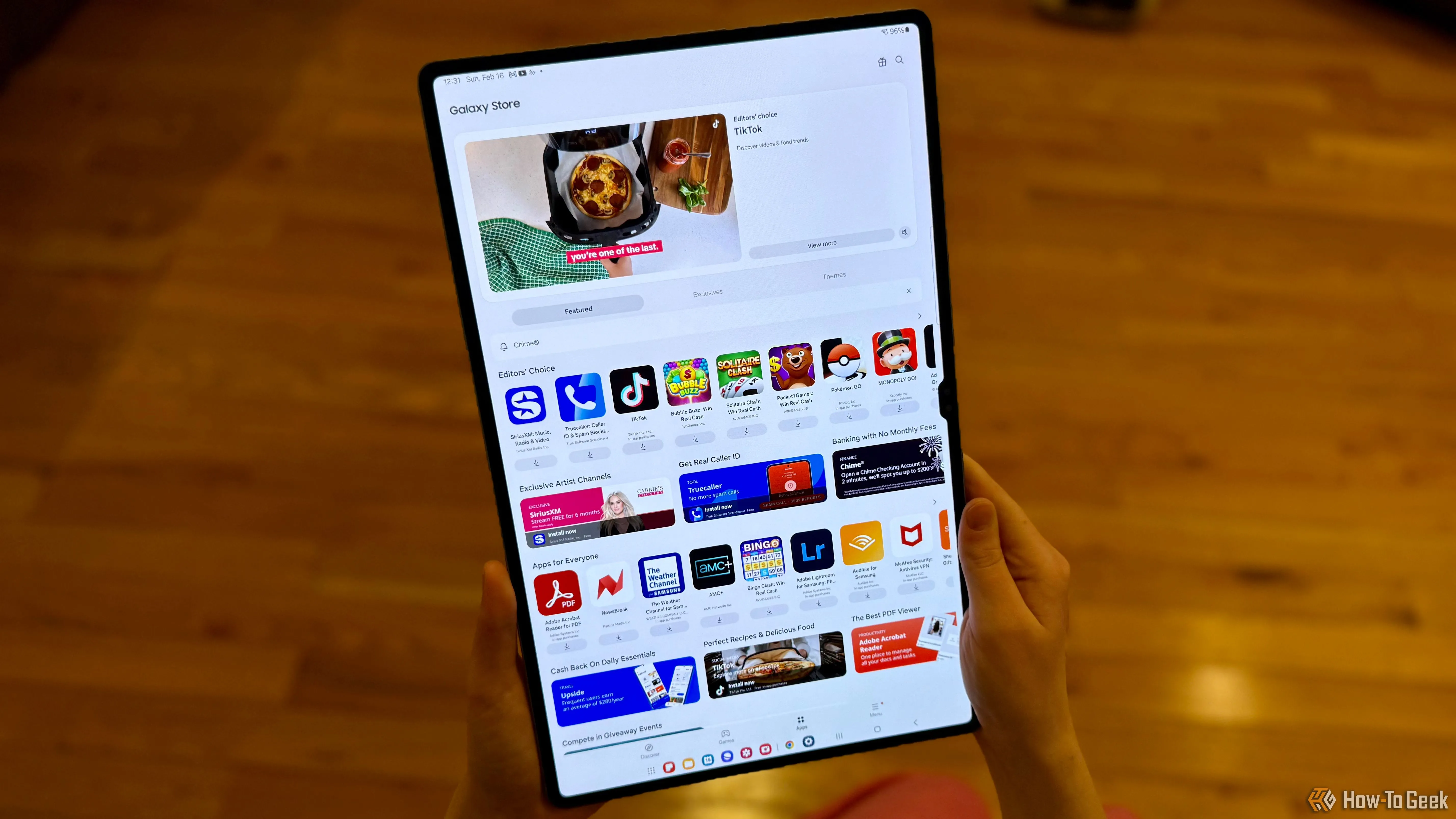 Một người dùng đang cầm chiếc Samsung Galaxy Tab S10 Ultra hiển thị ứng dụng Galaxy Store, minh họa kích thước lớn của máy tính bảng.