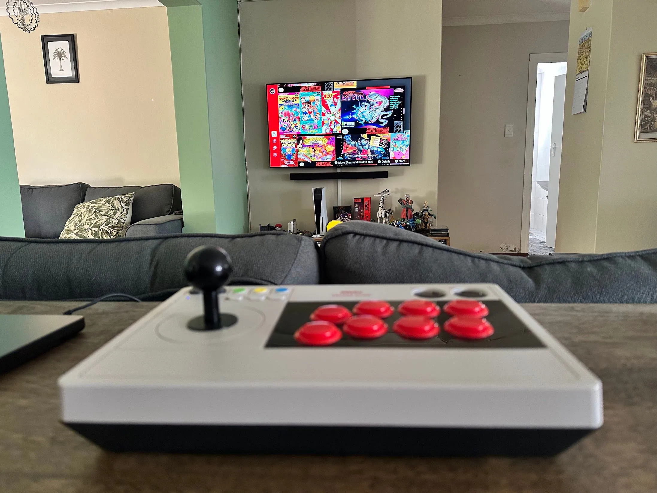 Một tay cầm arcade 8bitDo hiển thị trên màn hình với các tựa game SNES cổ điển.