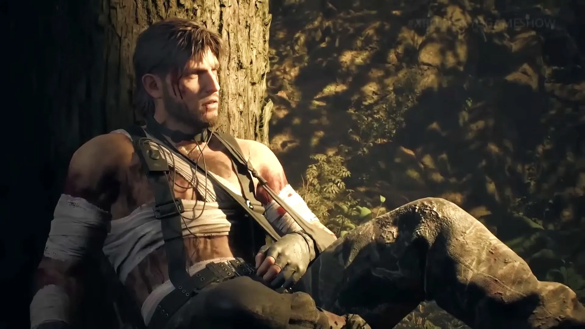 Naked Snake bị thương tựa vào gốc cây trong Metal Gear Solid Delta: Snake Eater, minh họa đồ họa cải tiến và bối cảnh sinh tồn khắc nghiệt của phiên bản remake.