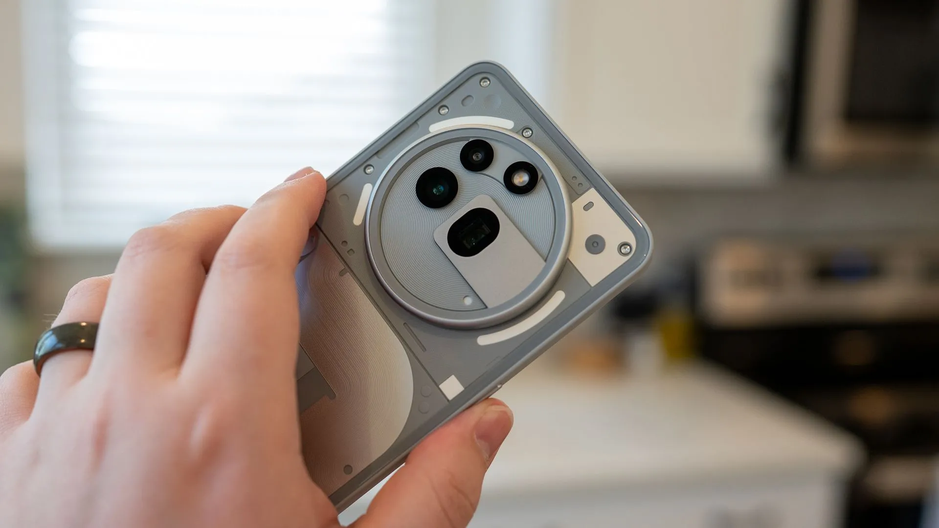 Người dùng cầm điện thoại Nothing Phone (3a) Pro tập trung vào thiết kế camera sau độc đáo