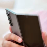 Người dùng cầm điện thoại Samsung Galaxy Z Fold 6 đang mở nhẹ, nhìn vào cụm camera sau
