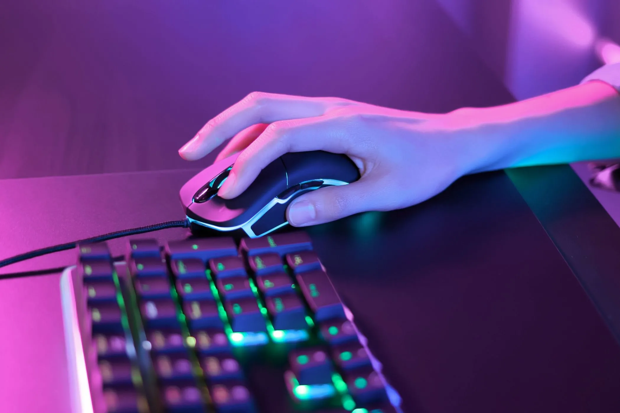 Người dùng đang chơi game với bàn phím và chuột gaming RGB