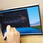 Người dùng đang viết hoặc vẽ trên màn hình cảm ứng laptop Lenovo Yoga 9i Gen 8 bằng bút stylus, thể hiện sự tiện lợi và đa năng của tính năng này.