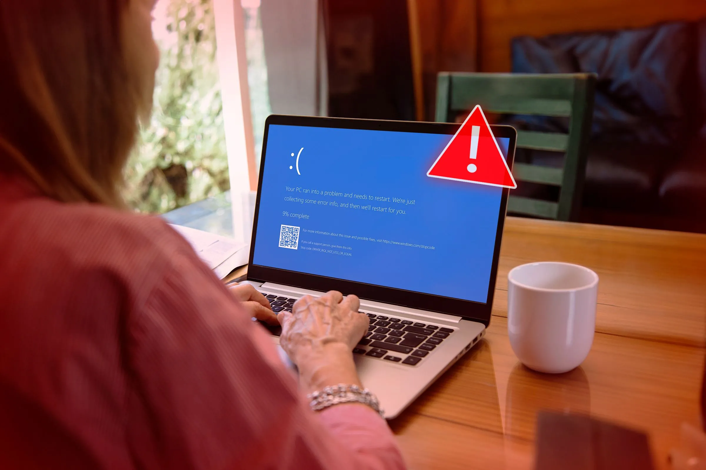 Người phụ nữ nhìn vào màn hình laptop hiển thị lỗi &quot;Blue Screen of Death&quot; (BSOD) quen thuộc, biểu tượng của sự thay đổi sắp tới trên Windows 11.