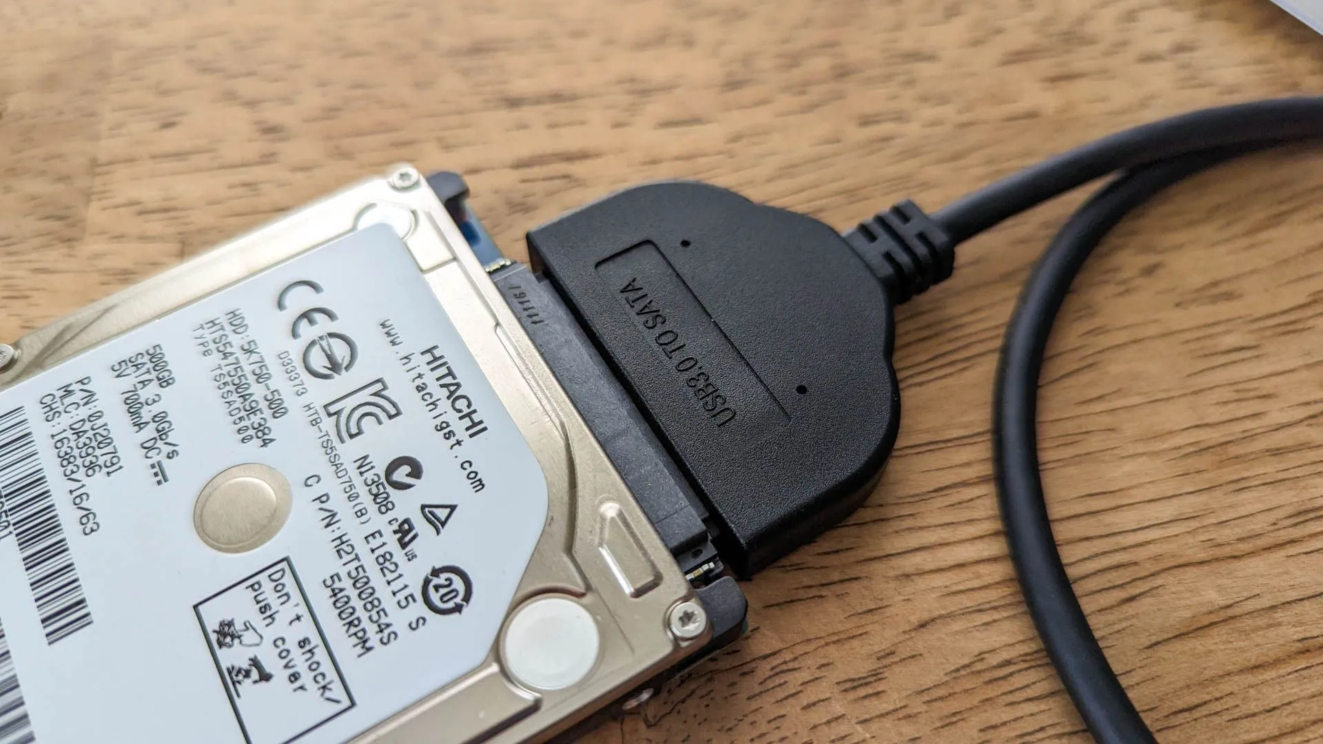 Ổ cứng laptop kết nối với bộ chuyển đổi USB sang SATA, tiện lợi cho việc kiểm tra hoặc sao lưu dữ liệu.