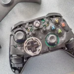 Tay cầm Xbox One với vỏ ngoài đã được tháo ra, hiển thị các linh kiện bên trong.