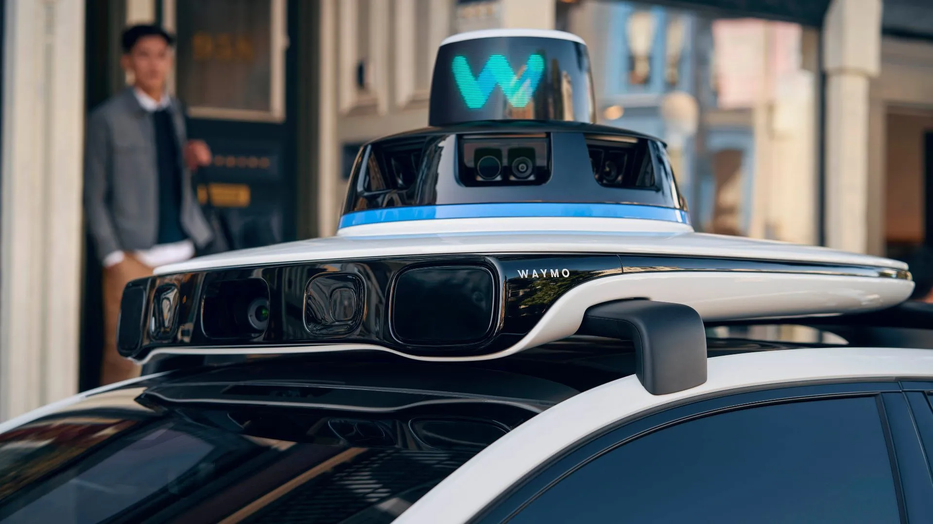 Xe taxi tự lái Waymo (Jaguar I-Pace) màu trắng với các cảm biến trên nóc và gương chiếu hậu